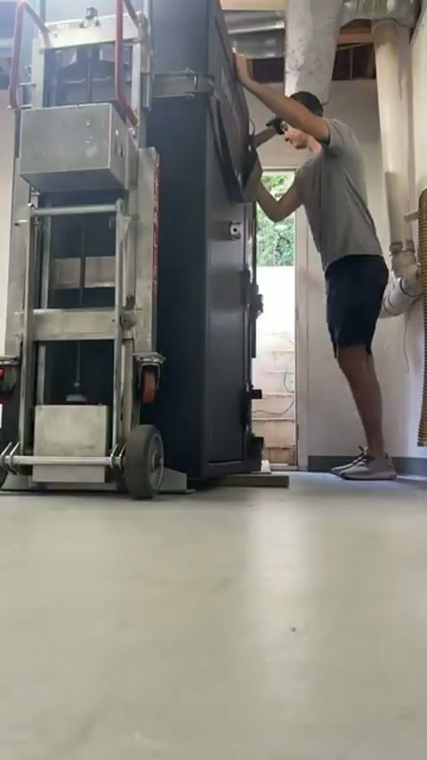 A mover uses a powered stair-climbing dolly to move a large safe up a flight of stairs to a doorway